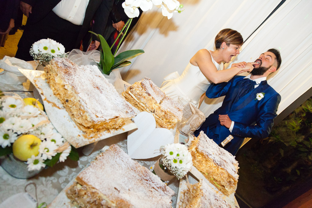 sposi scherzano durante il taglio della torta nuziale al ristorante corte poli